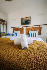 ein Schlafzimmer mit zwei Betten mit Handtüchern darauf in der Unterkunft Octopus House Caparica in Costa da Caparica
