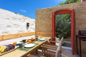 a wooden table with food on top of a patio at Platanos Cottage in Symi