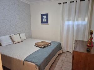 a bedroom with a bed with a dresser and a window at Oceano Azul in Porto Santo