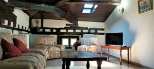 a living room with a couch and a tv and a table at Hosteria De Quijas in Quijas