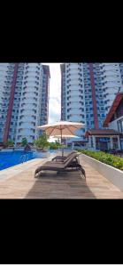 a table with an umbrella in front of some buildings at Royal Oceancrest Mactan - Relaxing Sunset View in Lapu Lapu City
