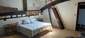 a bedroom with a bed with blue sheets and a staircase at Hosteria De Quijas in Quijas