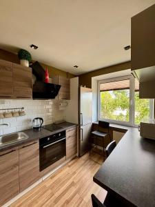 a kitchen with wooden cabinets and a sink and a window at Liepājā 4:10 pm in Liepāja