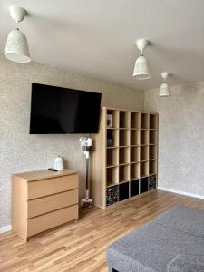 a bedroom with a tv on a wall with shelves at Liepājā 4:10 pm in Liepāja