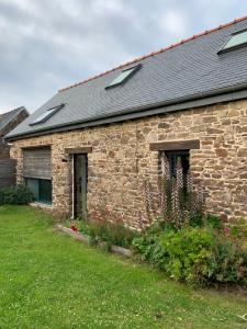 een stenen gebouw met twee ramen en een tuin bij Gîte de Kereveur, Loguivy de la Mer in Ploubazlanec