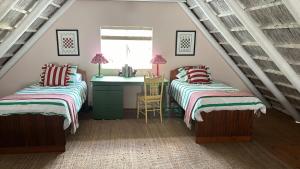 Cardigan Cottage في ماكغريغور: غرفة نوم علوية بسريرين ومغسلة