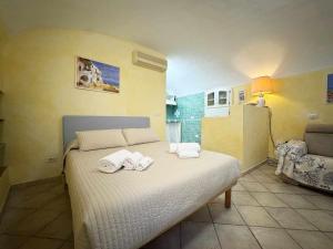 a bedroom with a bed with towels on it at La Maddalena Tour Holiday Home - Residenza Alibertini in La Maddalena +11 photos