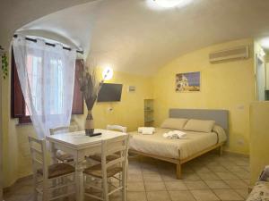 a bedroom with a bed and a table and chairs at La Maddalena Tour Holiday Home - Residenza Alibertini in La Maddalena