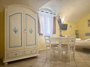 a dining room with a table and chairs and a bedroom at La Maddalena Tour Holiday Home - Residenza Alibertini in La Maddalena