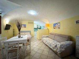 a living room with a couch and a table at La Maddalena Tour Holiday Home - Residenza Alibertini in La Maddalena