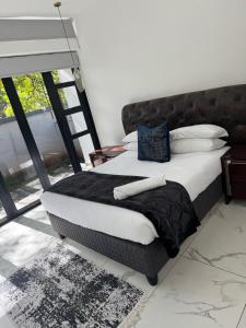 1 cama con sábanas blancas y almohadas azules en una habitación en Solar - powered Bryanston Home, en Johannesburgo
