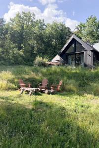 2 Stühle und ein Picknicktisch vor einer Hütte in der Unterkunft Maison de Reve avec Sauna en Pleine Foret in Le Vaudoué