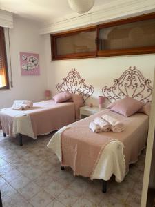 a bedroom with two beds with pink sheets at Villa Ada in Francavilla al Mare +30 photos
