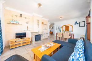 Una sala de estar con un sofá azul y una mesa. en vistamar sa rapita, en Sa Ràpita