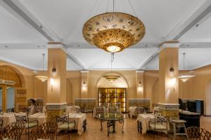 a restaurant with tables and chairs and a large chandelier at Royal Savoy Sharm El Sheikh in Sharm El Sheikh