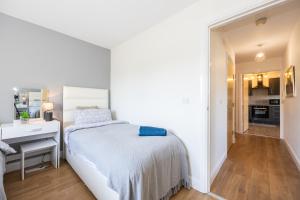 a white bedroom with a bed and a bathroom at Cosy, Central 2 Bed flat parking in Manchester