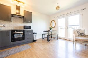 a kitchen with a counter and a table in it at Cosy, Central 2 Bed flat parking in Manchester +12 photos
