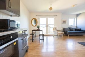 a living room with a kitchen and a living room with a couch at Cosy, Central 2 Bed flat parking in Manchester