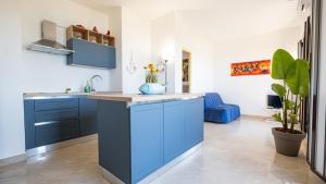 a kitchen with blue cabinets and a blue island at The Sicilian Sky Below in Trapani