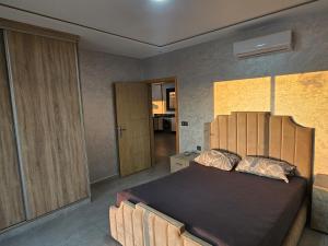 a bedroom with a bed with a wooden headboard at Villa Kazim in Berkane +9 photos