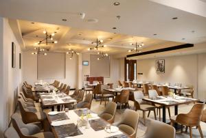 a restaurant with tables and chairs in a room at Goldencastle in Neyyāttinkara