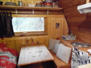 a room with a wooden table in a tiny house at Tonneau Col de la Faucille in Mijoux +12 photos