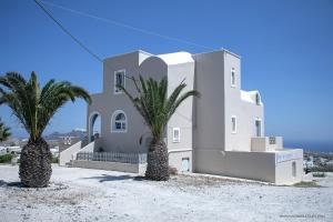 une maison blanche avec deux palmiers devant dans l'établissement Villa Anna with Panoramic sea views, à Pyrgos