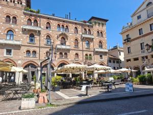a large brick building with tables and umbrellas at Al Portico in Treviso