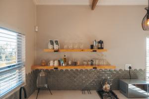 a kitchen with a counter with glasses on the wall at Swallow Cabin at Vrolikheid Landgoed in Tulbagh