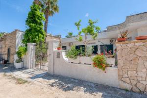 托雷拉皮罗La Corte del Geco的一座房子,上面有盆栽的栅栏