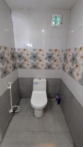 a bathroom with a white toilet in a stall at Tattamangalam village home stay in Tattamangalam