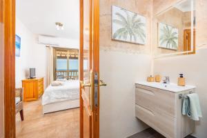 Un baño con lavabo y una cama en una habitación. en vistamar sa rapita, en Sa Ràpita