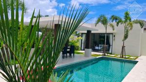 a villa with a swimming pool and a house at Santi Tara Villas in Amphoe Koh Samui