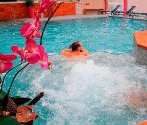 un hombre está en una piscina en Hotel & Spa Gil de France Cap d'Agde, en Cap d'Agde