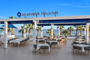 a restaurant on the beach with tables and chairs at Royal Savoy Sharm El Sheikh in Sharm El Sheikh