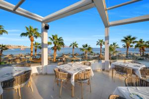 a patio with tables and chairs and a view of the ocean at Royal Savoy Sharm El Sheikh in Sharm El Sheikh