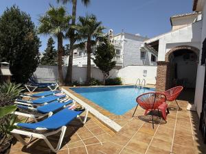 Una fila de tumbonas junto a una piscina. en Nerja Paradise Rentals - Villa Jazmines, en Nerja