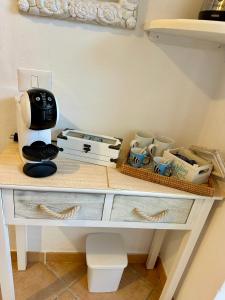 a table with a coffee maker and cups on it at Le Petite Suite in Porto Pozzo