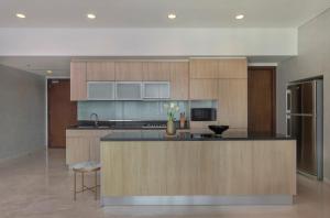 a kitchen with wooden cabinets and a counter top at Best 3 Bedroom Apartment in Mantaak