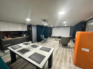a room with a table and chairs and a room with a screen at Vila Airport 24H in Chişinău