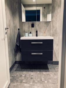 a bathroom with a sink and a mirror at Petersstova in Ålesund +4 photos