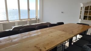 a large wooden table in a room with chairs at Zeezicht in Vlissingen