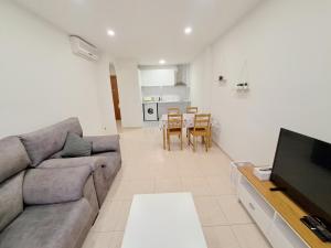 a living room with a couch and a flat screen tv at 2a Línea de Mar, Playa de Lloret, Centro Histórico in Lloret de Mar