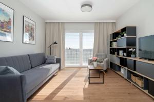 ポズナンにあるBright Apartment Bulgarska with Parking near ENEA Stadium by Noclegi Rentersのソファとテレビのあるリビングルーム