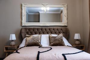 a bedroom with a large mirror above a bed at Apartment 2 in Chepstow +1 photo