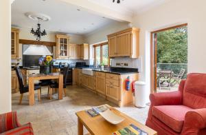 a kitchen with a couch and a table in a room at Luccombe Chine House - Rare Find - Spectacular Secluded Coastal Manor, Breathtaking Ocean Views short drive to Shanklin or Ventnor Beach - near Shanklin Old Village in Shanklin