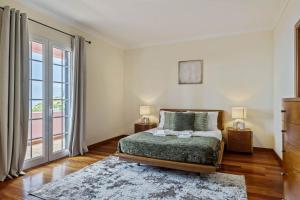a bedroom with a bed and a large window at Amendoeira Residence by Homie in Quinta do Almeida