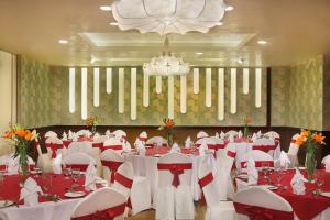 a banquet hall with red and white tables and chairs at City Seasons Al Hamra Hotel in Abu Dhabi
