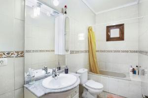 a bathroom with a sink and a toilet and a tub at Casa La Cabaña in Gáldar +31 photos