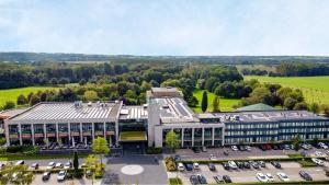 Una vista aérea de un edificio con estacionamiento. en Van der Valk Hotel Heerlen, en Heerlen